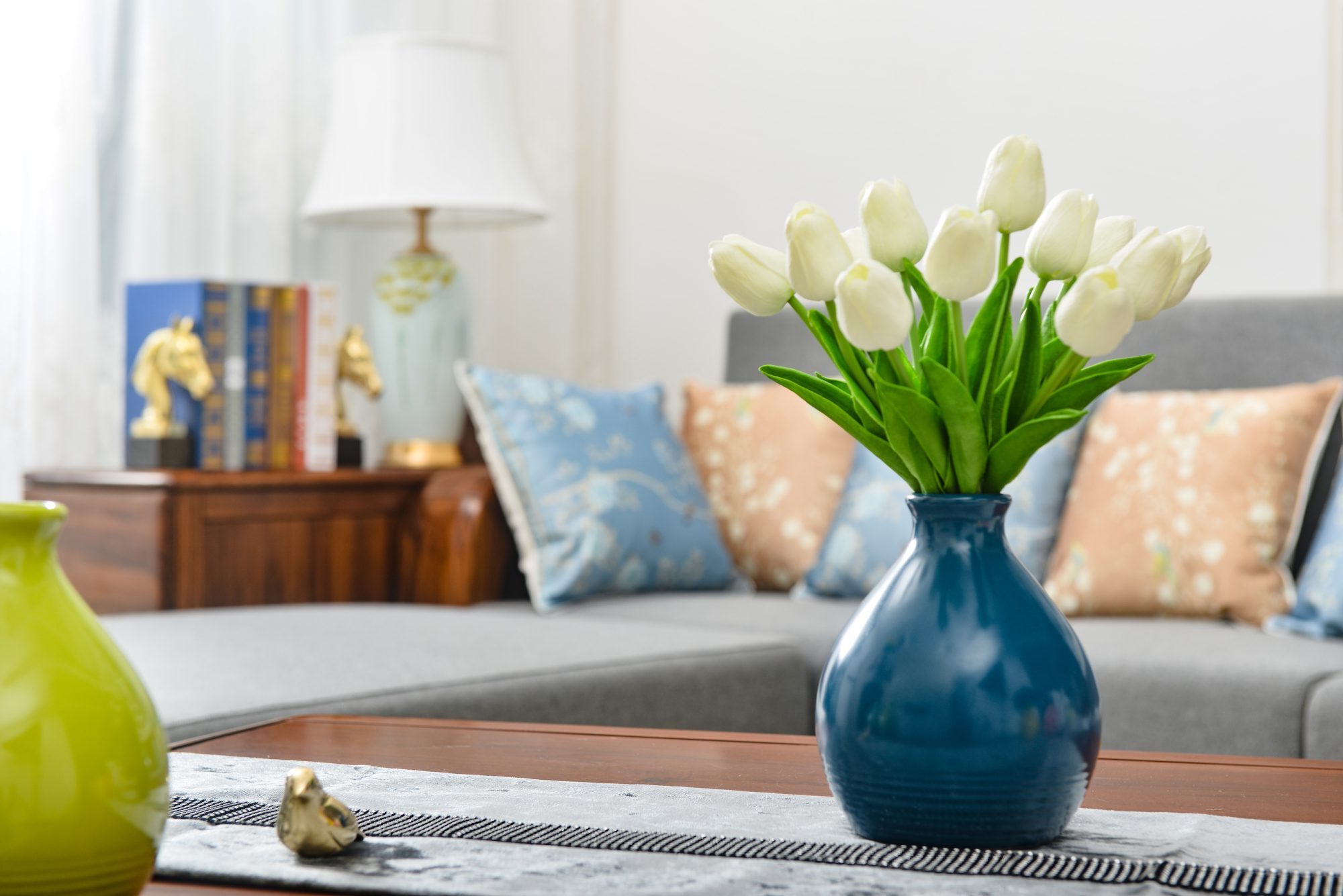 Home interior decor,tulip bouquet in a vase on wooden table runner, in living room